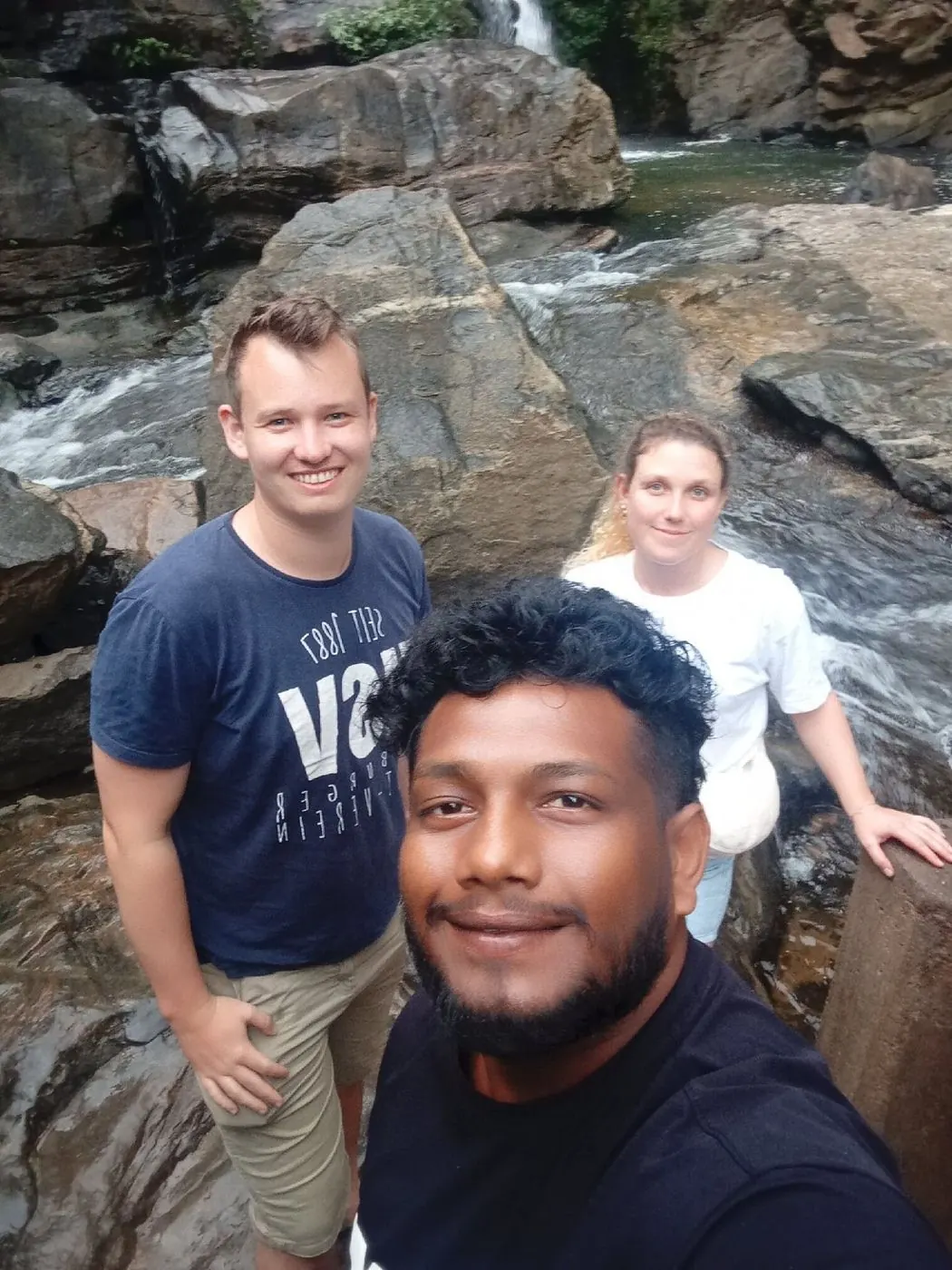 Dinu taking a photo with two guests by a river
