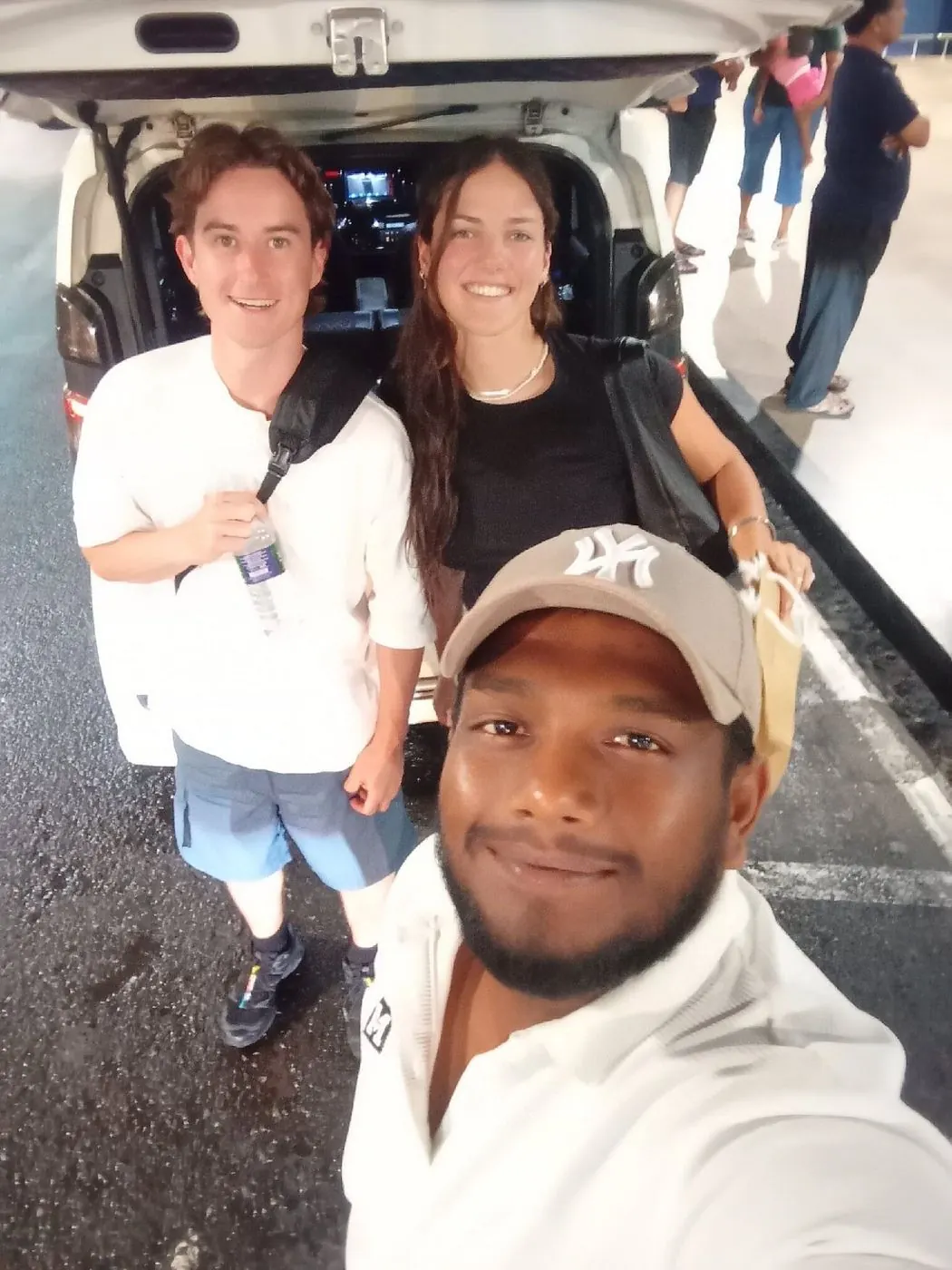 Dinu welcoming two guests at the airport