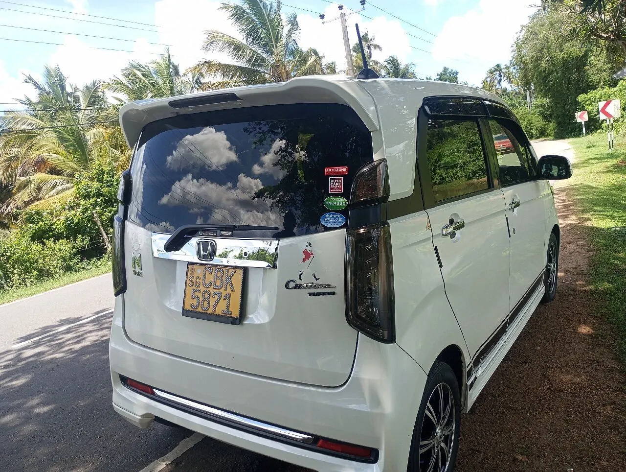 Dinu's car on a road lined with palm trees